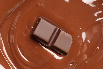 Tasty melted chocolate and piece as background, top view