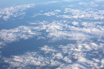 Fototapeta premium Aircraft window view of fluffy white clouds over Romania, Europe. Aerial view cloudscape.