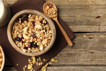 Tasty granola with dried fruits, nuts and milk on wooden table, flat lay. Space for text