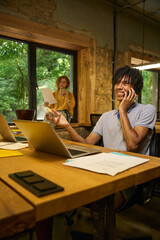 Man on a phone call while working on laptop