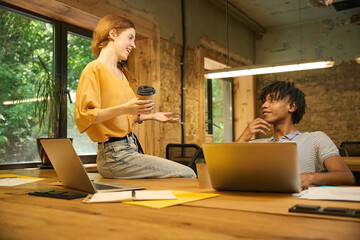 Woman showing something on her phone to a seated man