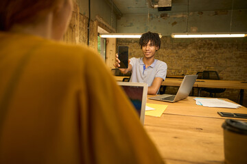 Colleague showing a phone to a woman