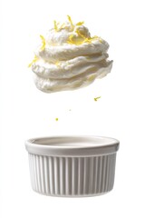 Whipped cream with lemon zest levitating over a ramekin, representing lightness, freshness, and delicious dessert preparation