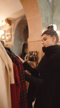 boutique buyer woman inspecting tailored coats under arches