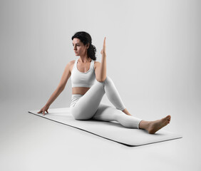 Mockup of white floor mat for yoga, trainer in asana, set of clothes for design, branding.
