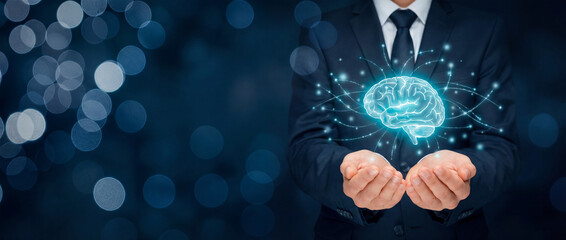 A businessman in a suit holding a glowing holographic brain, representing artificial intelligence, digital thinking, and modern technological innovation.