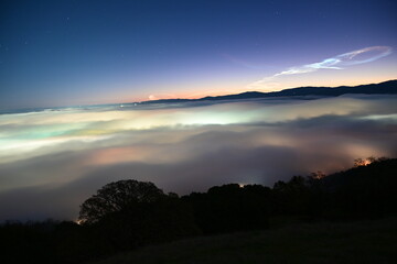 beautiful city lights through the fog and clouds