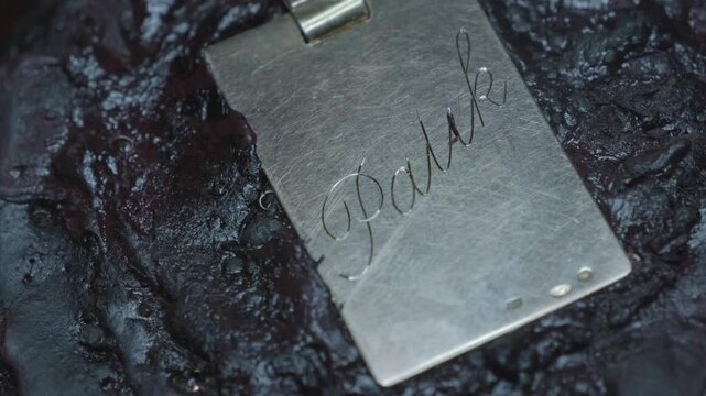 Hand engraving elegant cursive script letters into gold jewelry pendant closeup macro detail