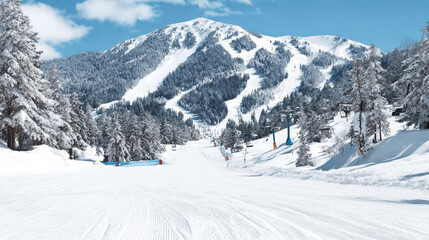 Winter ski resort landscape featuring snow covered mountains, groomed slopes, and empty chairlifts preparing for skiers