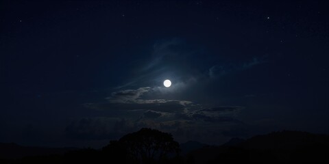 Fototapeta premium Moon shining in the dark night sky over a rural landscape, nocturnal illumination