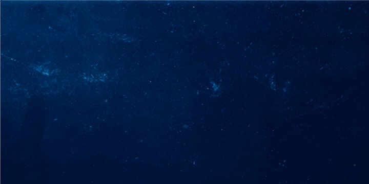 Dark blue grunge texture background with abstract light rays suggesting night sky galaxy stars or deep sea water motion
