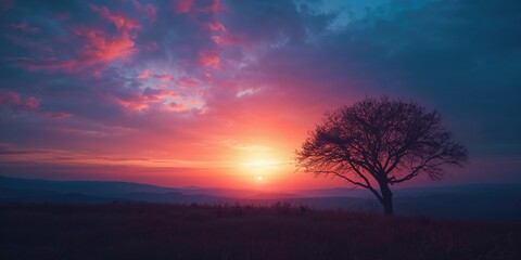 Evening sunset casting warm orange tones over a landscape with shifting blue and purple colors, suitable for nature backgrounds