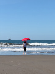 Kid stand with red umbrella