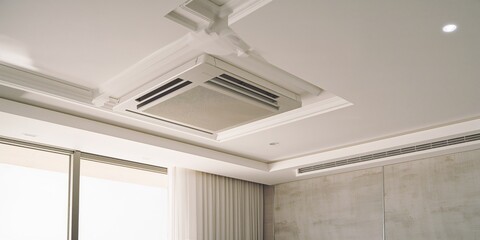Fototapeta premium Modern apartment ceiling with suspended drywall and grey stretch ceiling, equipped with air conditioning for climate control