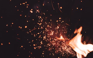 A captivating close up of glowing embers and dancing flames in darkness