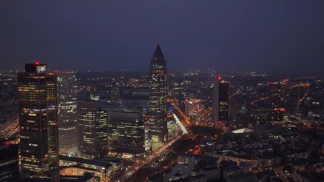 Tripod aerial view from unique perspective of Messeturm in Frankfurt Fair area. Financial district's illuminated skyscrapers create vibrant cityscape