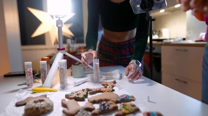 Woman practicing cookie decoration in festive kitchen setting