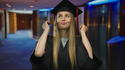 Woman in graduation cap with humorous expression indoors at a hotel corridor illustrating a moment of surprise and achievement captured in vivid detail.