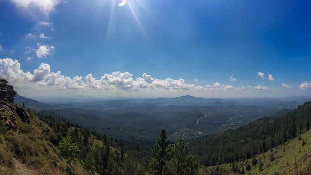 Breathtaking panoramic view of vibrant mountain landscape during daytime showcasing lush green forests rolling hills and a clear blue sky with fluffy clouds under bright sunlight