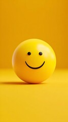 Fototapeta premium High quality image of smooth yellow sphere with a simple black smiley face on a vibrant yellow background.