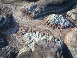 Aerial view of the textured landscape, where layers of earth create a striking visual tapestry of whites, reds, and browns, Nazlini, Arizona, United States.
