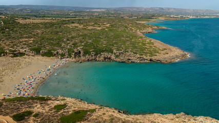 Aerial view of Cala Mosche (or Calamosche) beach, a beautiful sandy beach within the Vendicari Nature Reserve, in province of Syracuse, Sicily, Italy. In background is visible the town of Noto.