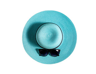 Stylish summer hat and sunglasses among tropical leaves 