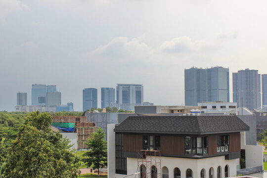 Jakarta, Indonesia - 01 January 2026: View of office buildings in the BSD City business district from a distance with a modern house in the foreground.