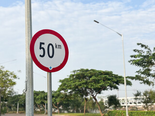 A clear and modern close-up shot of a circular speed limit sign displaying the number 50 km (kilometers per hour) in black against a white background with a prominent red border.