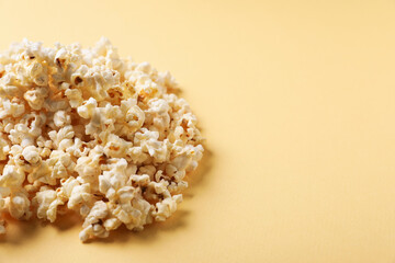 Fresh tasty popcorn on beige background, closeup. Space for text
