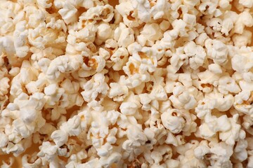 Fresh tasty popcorn as background, top view