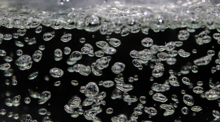 Spherical air bubbles nestled against a dark background.