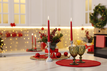 Christmas decor and glasses on light marble table in kitchen, space for text. Interior design