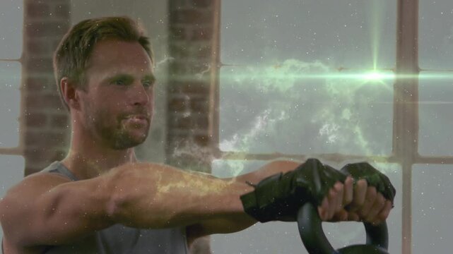 Man reaching, lifting kettlebell in gym, training while nebula particles and lens flares crossing