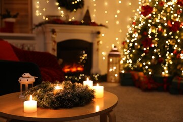 Coffee table with burning candles, fireplace, Christmas tree and festive decor in dark room, selective focus. Bokeh effect