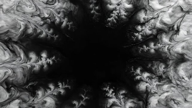 Abstract black ink spreading and diffusing dramatically on a textured white paper surface creating a dark cloud