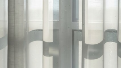 Curtain silhouette in the sunlight: a minimalist composition. The soft, translucent curtain filters the sunlight, creating a play of shadows and highlighting the fabric's texture.