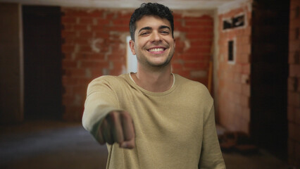 Obraz premium Man makes fist bump at construction zone to greet young hispanic worker on site by builder male.