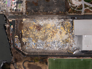 Aerial view of a landscape of rubble and debris, a stark reminder of urban change, contrasting against the adjacent green field, Brooklyn, New York, United States.
