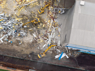 Aerial view of heavy machinery tearing through a building, leaving a trail of debris and destruction, Brooklyn, New York, United States.