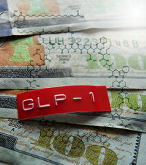 GLP-1 label and semaglutide molecule structure on assorted one hundred dollar bills