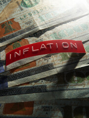 Red Inflation label on a pile of US hundred dollar bills