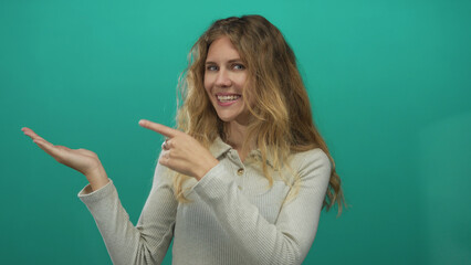 Woman hand pointing studio blonde young smiling palm green screen backdrop conveys promotional potential.