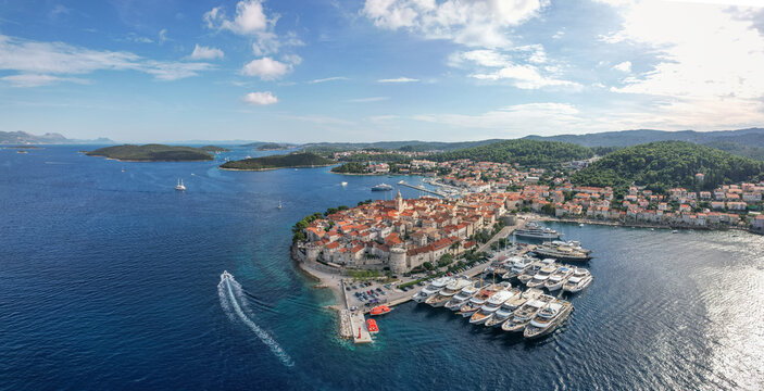 Aerial view of terracotta rooftops cascade down to meet the azure sea, where yachts bob gently in the harbor, Korcula, Dubrovnik-Neretva County, Croatia.
