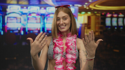 Young woman with tattoos and floral lei posing indoors in a vibrant casino with slot machines.