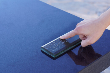 Finger reading braille tactile on public park message board