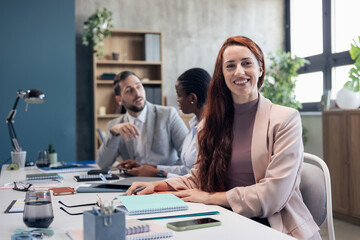 Obraz premium Confident businesswoman smiling at office team meeting