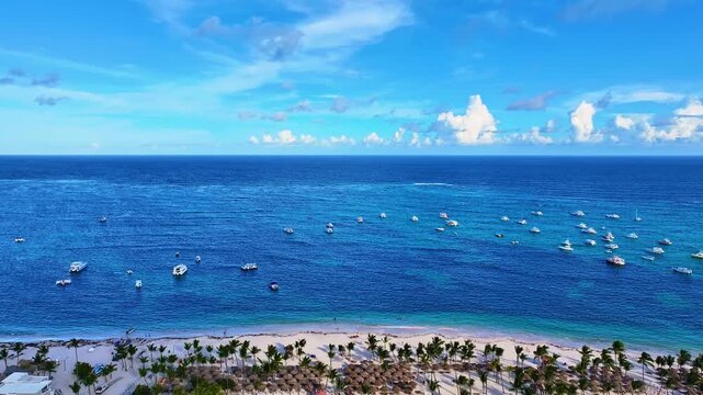 A bird's-eye view of the azure evening sea with white ships. A beautiful seascape off a resort palm beach with umbrellas. Discover a paradise for divers and nature lovers. Clouds over the ocean.
