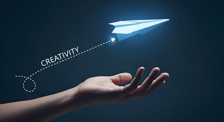 Hand launching a glowing paper airplane with creativity trajectory on dark blue background, symbolizing innovative ideas and imagination