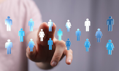 Hand pressing a virtual human figure. Concept of social network, recruitment, team, or human resources.